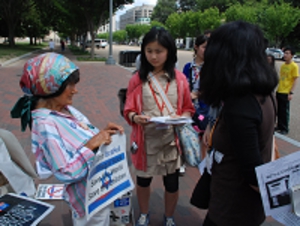 ホワイトハウス前で核兵器廃絶を訴える女性を取材する中高生記者.JPG